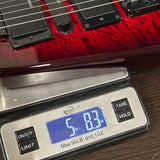 Digital scale displaying weight of a red electric guitar