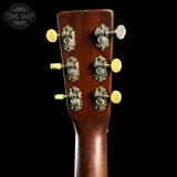 Close-up of a guitar headstock with tuning pegs on a black background, featuring the Tone Shop logo.