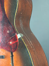 Close-up of a wooden instrument with a focus on the soundpost and wood grain.