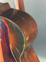 Close-up of a wooden guitar's soundhole with a plain background