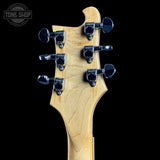 Guitar headstock with tuning pegs on a black background, featuring the Tone Shop logo.