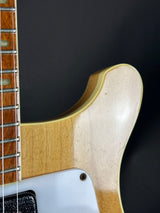 Close-up of a guitar's neck and headstock on a black background