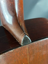 Close-up of a wooden chair arm with a metal bracket.