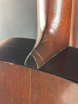 Close-up of a wooden chair arm with a visible crack.
