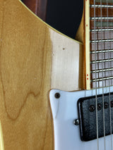 Close-up of a guitar's neck and body with visible wood grain.
