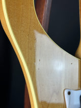 Close-up of a guitar's body with a visible scratch on the wood.