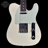 A classic Fender Telecaster-style electric guitar body in cream/off-white, featuring a light greenish-white pickguard, black hardware, and a dark fretboard, shown against a solid black background with a Tone Shop watermark in the top left.