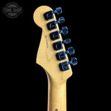 Guitar headstock with six tuning pegs on a black background, featuring the Tone Shop logo.