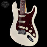 White electric guitar with a dark red pickguard on a black background, featuring 'Tone Shop' logo.
