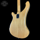 Back view of a wooden electric guitar with 'Tone Shop' logo in the corner.