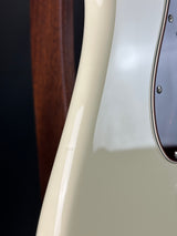 Close-up of a guitar's neck and headstock with a white pickguard.