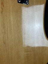 Close-up of a guitar neck with white filler on a brown background
