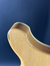 Close-up of a wooden spoon handle with a small crack on a dark blue background