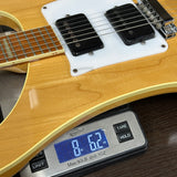 Electric guitar being weighed on a digital scale with a wooden finish.