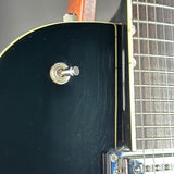Close-up of the side of a black electric guitar body with a silver toggle switch, showing some surface scratches on the finish and part of the fretboard.