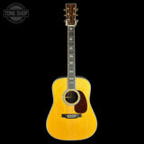 Acoustic guitar with a visible brand logo on a black background