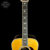Acoustic guitar with a black background and 'Tone Shop' logo.