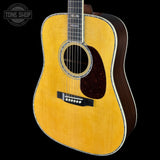 Acoustic guitar with a visible brand logo on a black background