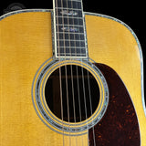 Close-up of an acoustic guitar's soundhole and fretboard on a black background