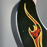 Close-up of a glossy black guitar body featuring a decorative flame-style inlay in red and yellow, with a small portion of a light-colored wood edge visible at the top.