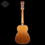 The back of a wooden acoustic guitar, showing the natural wood grain and headstock, photographed against a solid black background with a Tone Shop watermark in the top left corner.