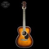 A vintage-style acoustic guitar with a sunburst finish, shown from the front against a solid black background. The brand name 'Martin' is visible on the headstock.
