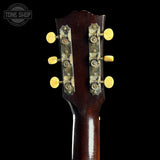 Close-up of a guitar headstock with tuning pegs on a black background, featuring 'Tone Shop' branding.