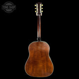 Back view of a wooden acoustic guitar on a black background with 'Tone Shop' logo.