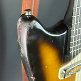 Close-up of a guitar's neck and headstock with a blurred background