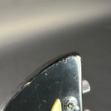 Close-up of a metal tool with a black handle on a dark background