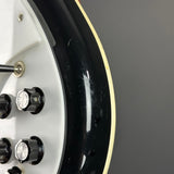 Close-up of a motorcycle wheel with black rim and white hub on a gray background