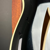 Close-up of a guitar's neck and headstock with a wooden finish.