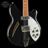 Black and white electric guitar with a visible brand logo in the corner.