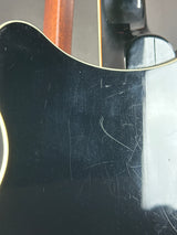 Scratched black guitar body with a reflection on a white background