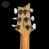 Close-up of the headstock of a guitar, showing six white tuning pegs, black tuning mechanisms, and the brand name 'Wood Legacy' printed vertically on a black background.