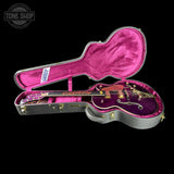 Purple Gretsch guitar in a pink case with 'Tone Shop' logo.