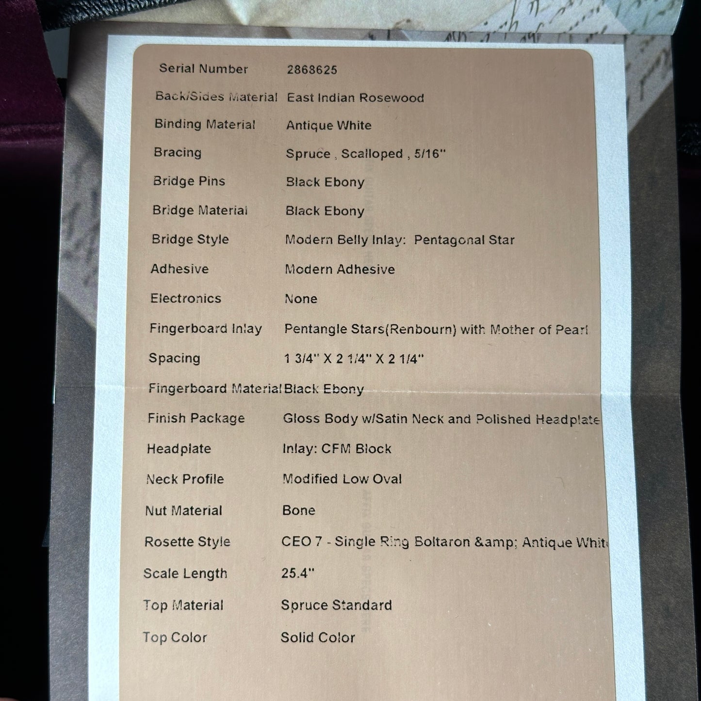 Technical specifications sheet for a guitar on a cardboard background