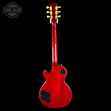 A red electric guitar shown from the back against a solid black background, with a Tone Shop watermark in the upper left corner.