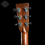 Close-up of the headstock of a wooden acoustic guitar, showing six decorative silver tuning pegs on a glossy brown wood finish against a black background. A 'TONE SHOP' watermark is visible in the top left corner.