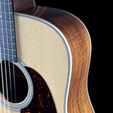 Close-up of an acoustic guitar's body and neck on a black background
