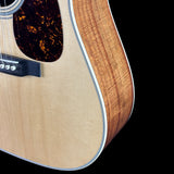 Close-up of a wooden acoustic guitar on a black background