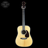 Acoustic guitar with a visible brand logo on a black background