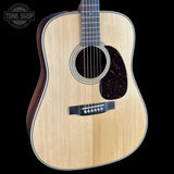 Acoustic guitar with a visible brand logo on a black background