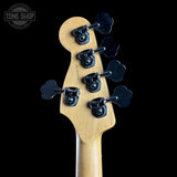 Close-up of the headstock of an electric bass guitar, showing six black tuning pegs on a natural maple neck against a solid black background. A 'TONE SHOP' watermark is visible in the top left corner.