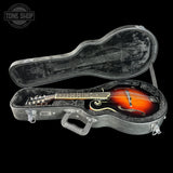 Mandolin in an open case with 'Tone Shop' logo in the corner.