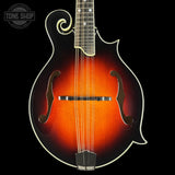 Mandolin with a dark brown finish on a black background, featuring the Tone Shop logo.