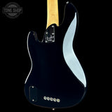 The back of a Fender Stratocaster electric guitar with a glossy black finish, showing the maple neck, control plate, and tailpiece against a black background.