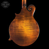 Close-up of a wooden mandolin back with 'Tone Shop' logo in the corner.