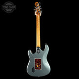 Electric guitar with a wooden neck on a black background, featuring the Tone Shop logo.
