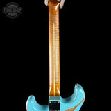 Close-up of the back of an electric guitar showing a bright turquoise blue body with a heavily distressed finish and a natural flamed maple neck, set against a solid black background.